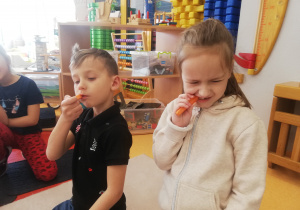 chłopiec z dziewczynką jedzą marchewki